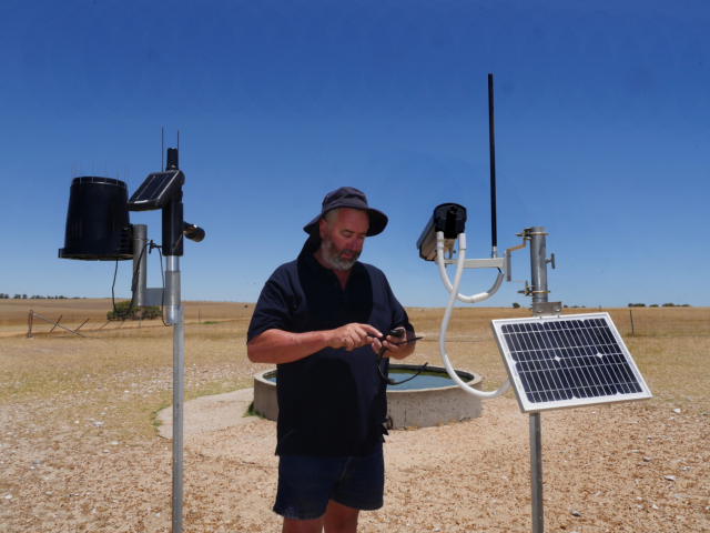 Mr Patmore with two different brands of remote cameras that he uses on the property.  The cameras take images of the water trough at set intervals which can then be downloaded to a phone.