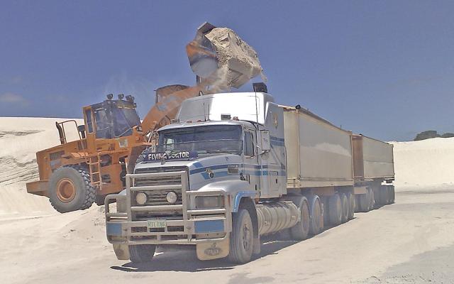 Loader filling a heavy haulage truck with agriculural lime.