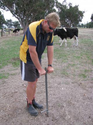 Photograph of a person leaning on a manual pogo stick soil sampler