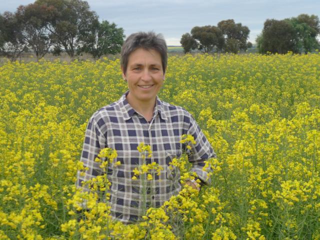 Research Officer Imma Farre standing in canola crop in full flower