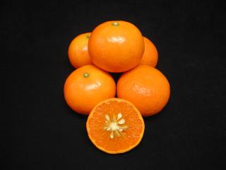 Murcott mandarin cut in half with five in a pile behind.