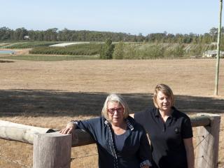 Photo caption: Grower Ann Lyster and Department of Agriculture and Food development office Susie Murphy White at the netting trial site on the Lysters’ property.