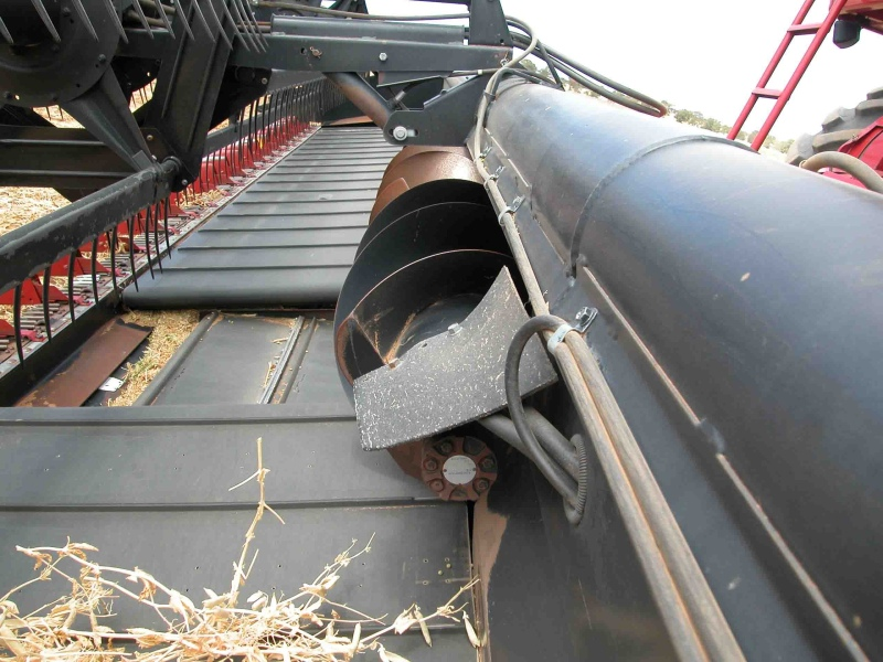 Moving the broad elevator auger forward can improve feeding of light material into harvester.